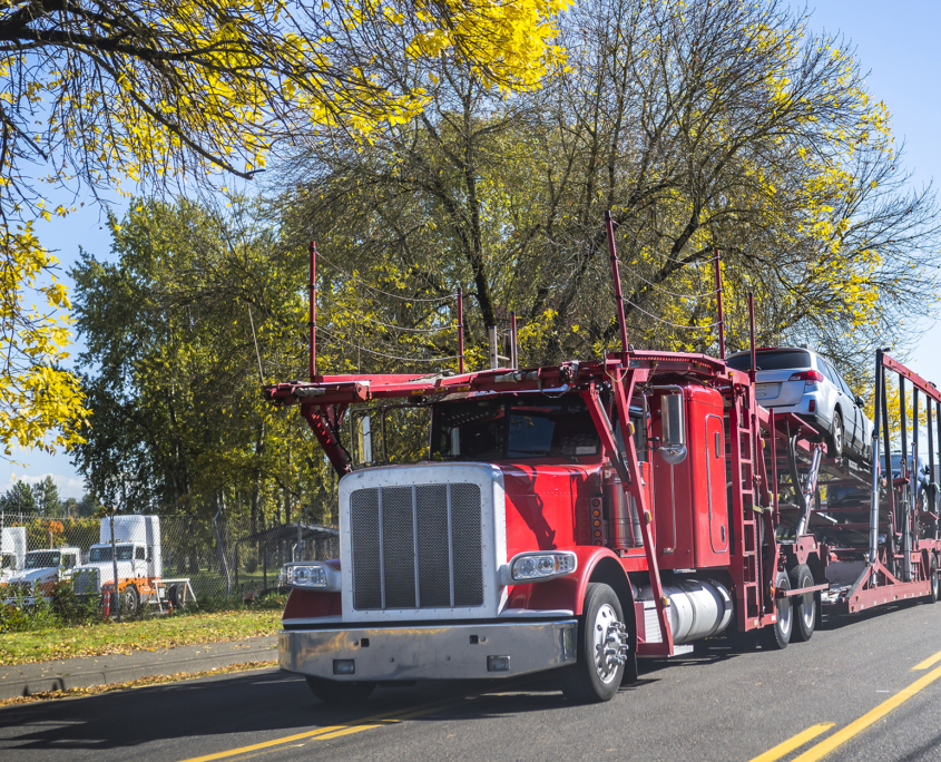 Front View of Red Truck Hauling Cars on the Road
