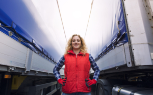 Woman Standing Between Two Conestoga Trucks